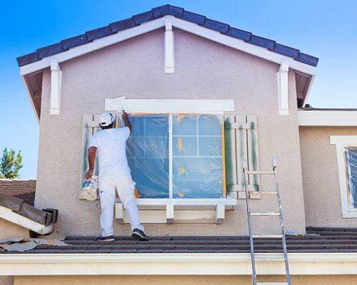 Busy House Painter Painting the Trim And Shutters of A Home.